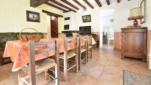 A dining area with wooden chairs and a table, a television, and a cabinet. - Charming Holiday Home With Pool and Pond (Villentrois-Faverolles-en-Berry)