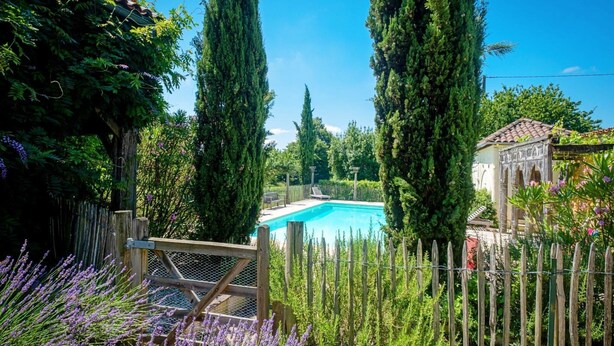 A swimming pool surrounded by tall trees and a wooden fence. - Beautiful Farmhouse With Private Pool (Perchede)
