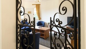 A living room with a sofa, a coffee table, and a TV. - Sunny Villa Stay in Nyons (Nyons)