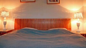 Ein Hotelzimmer mit einem Bett, zwei Lampen und zwei Bildern an der Wand.