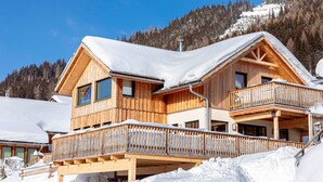A wooden chalet with a balcony, surrounded by snow-covered mountains. - Nice Chalet With Terrace (Hohentauern)