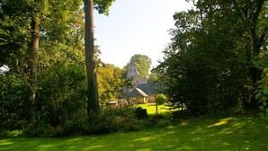 A church surrounded by lush greenery. - Bungalow in France Near Castle & Hiking Trails (Saint-Pierre-le-Vieux)