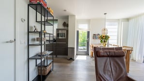 Una cocina moderna con horno empotrado y comedor con mesa y sillas.