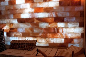 Habitació amb un mur amb relleu, una estructura de fusta i una cadira de fusta.