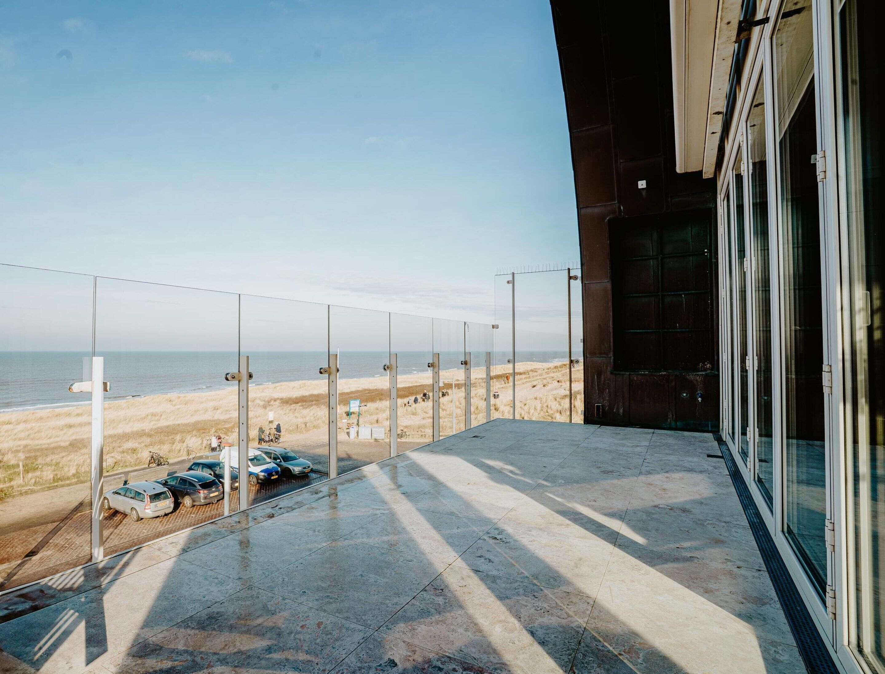 Un balcon avec vue sur la plage et l’océan.