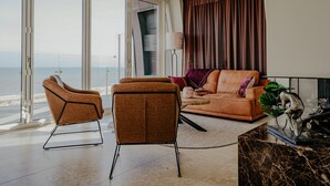 A spacious living room with a large sliding glass door leading to a balcony overlooking the sea. - Apartment in Egmond With Sea Views (Egmond aan Zee)