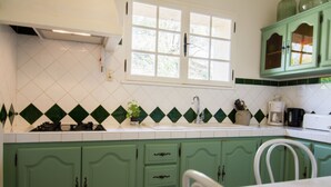 A kitchen with green cabinets, a white countertop, a window, and a sink. - Villa in Campagnan With Pool and Vineyard Views (Campagnan)