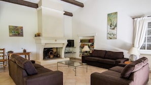 A living room with a fireplace, two sofas, a coffee table, and a bookshelf. - Villa in Campagnan With Pool and Vineyard Views (Campagnan)