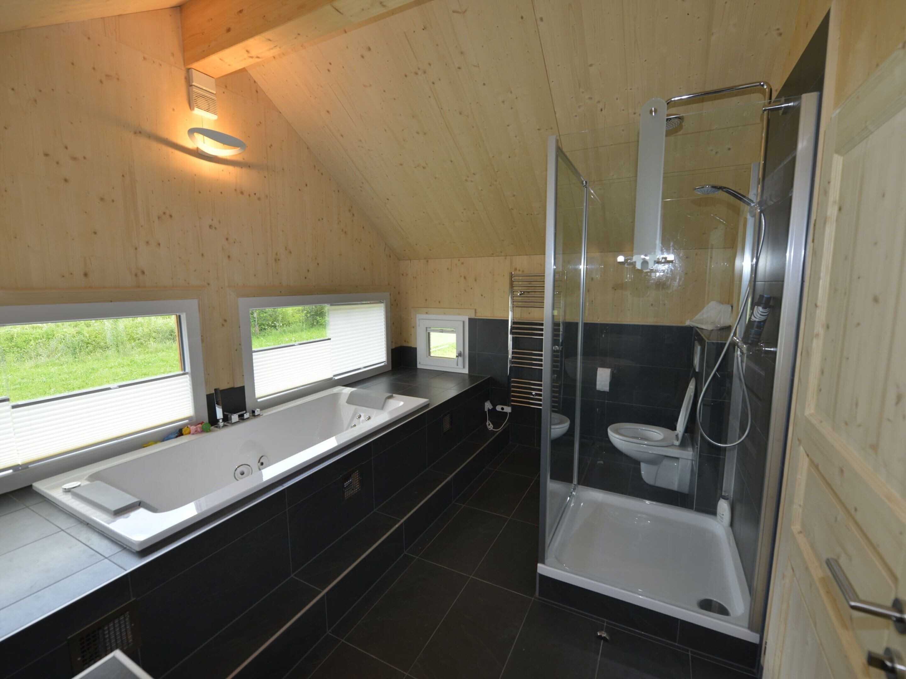 Un baño moderno con una bañera grande, cabina de ducha independiente y dos lavamanos.
