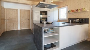 Een moderne keuken met houten wanden, een centraal eiland en ingebouwde apparatuur.