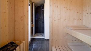 A wooden sauna room with a glass door leading to a shower area. - Charming Chalet With Whirlpool (Sankt Georgen am Kreischberg)