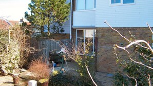 Ein zweistöckiges Haus mit Ziegelverkleidung und weißem Außenputz.