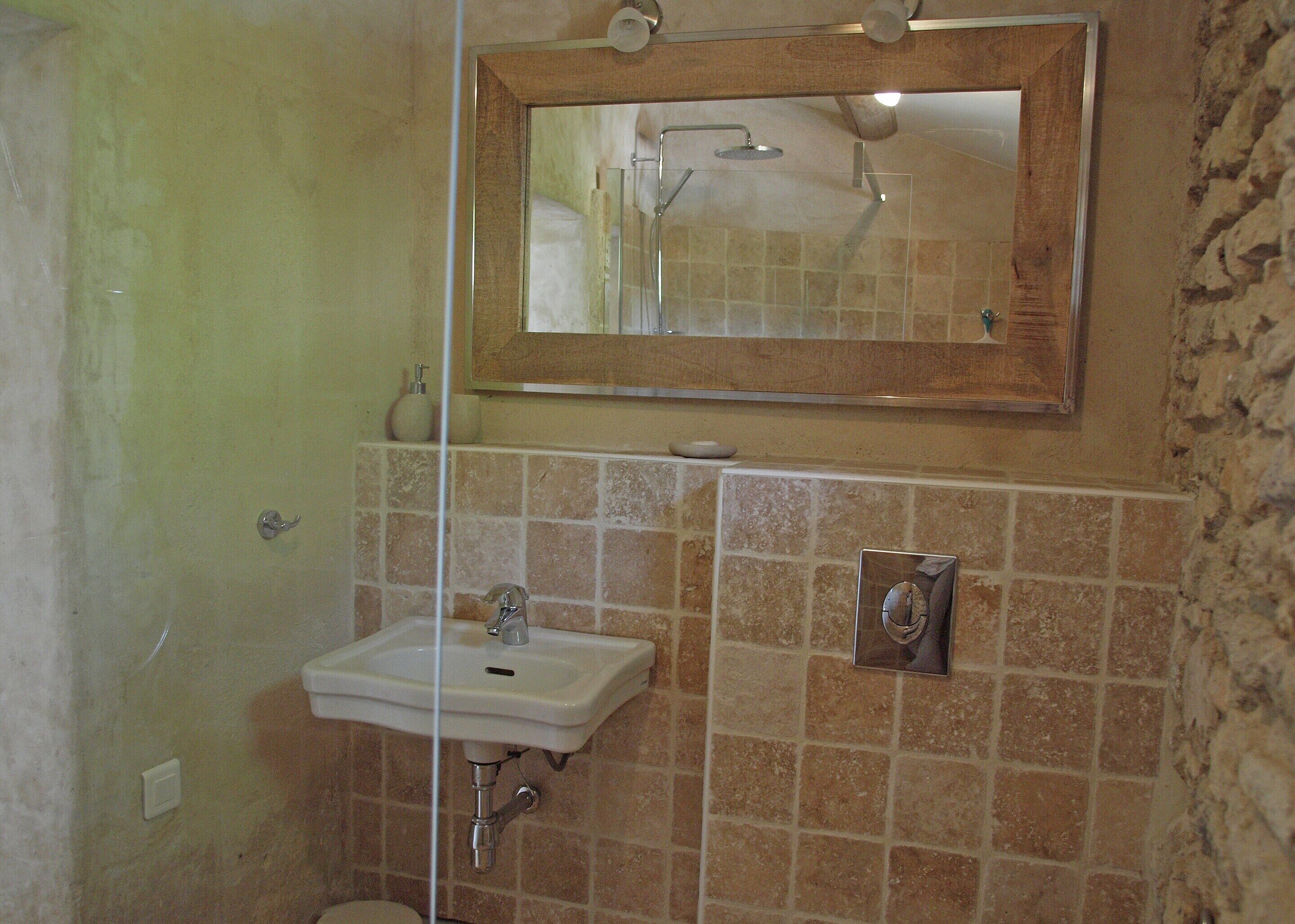 A bathroom with a shower, sink, and mirror.