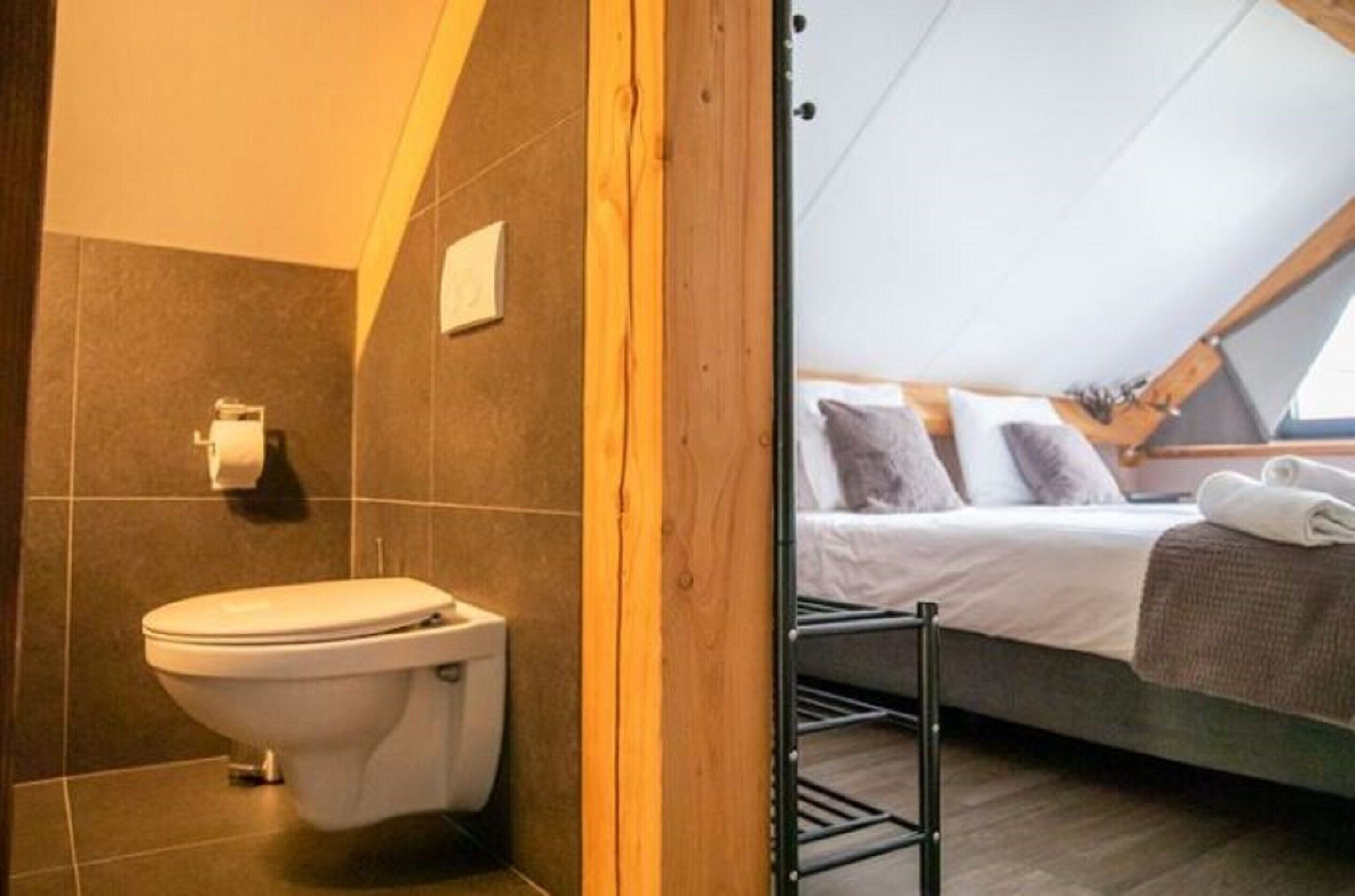 A compact, modern bathroom with a toilet and a shower area.