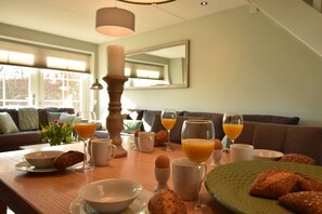 A breakfast table with bread, eggs, and orange juice. - Villa in Schoorldam With Garden (Warmenhuizen)