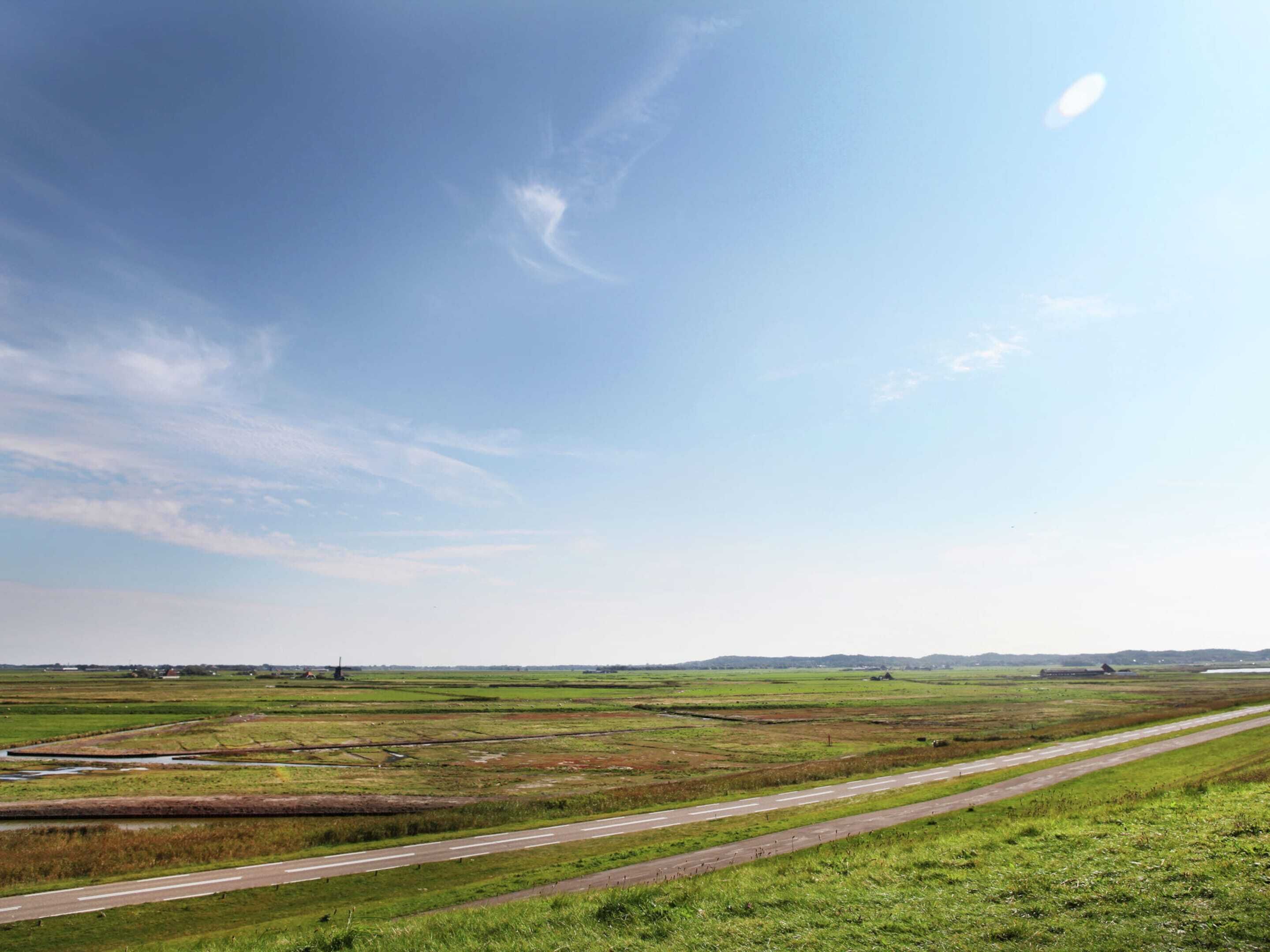 A wide, open landscape with a clear sky and a runway.