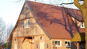 A wooden building with a sloped roof, a wooden door, and a window.