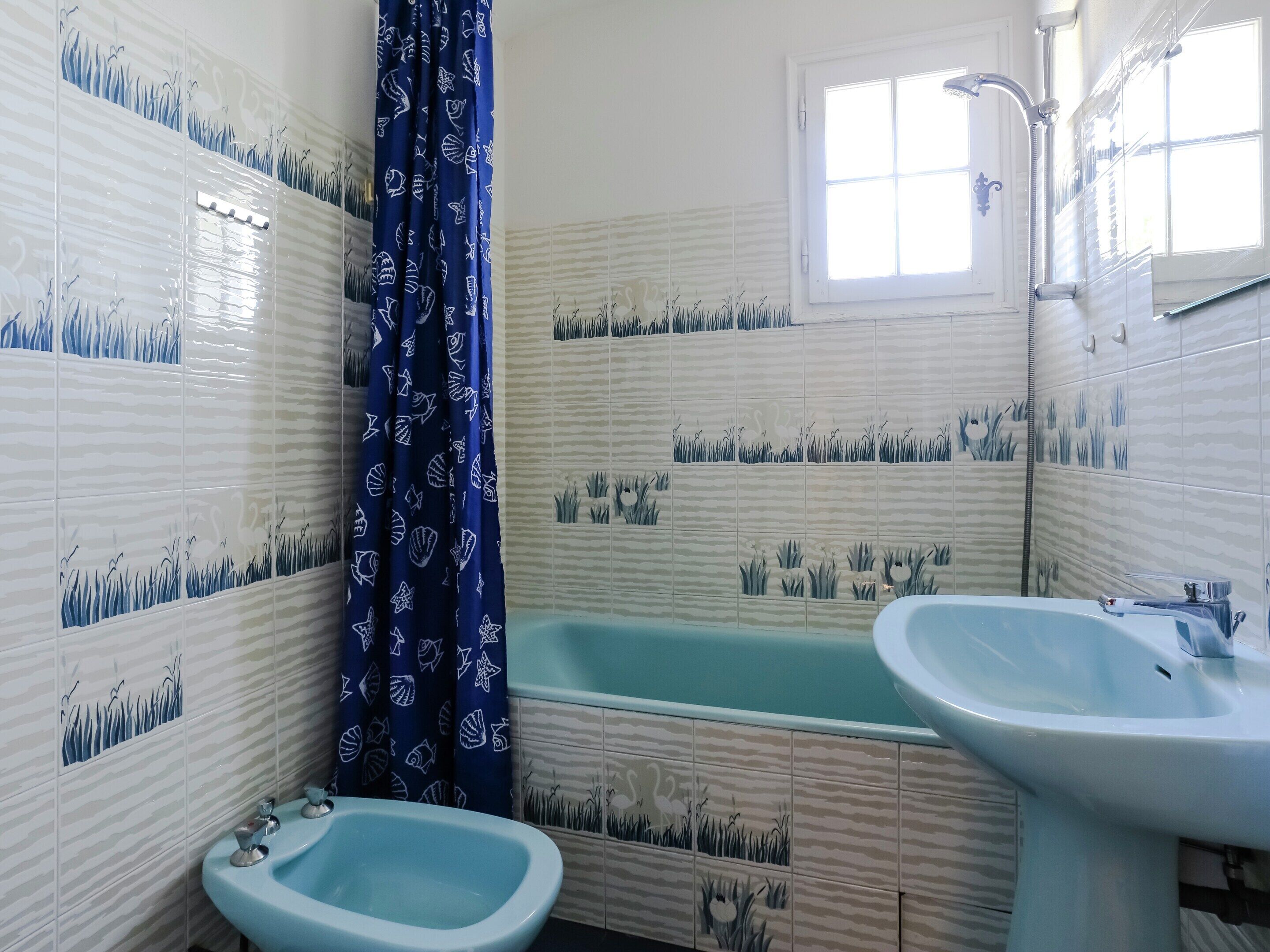 Et badeværelse med badekar, bidet og håndvask.