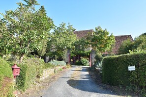 A rural pathway leading to a traditional stone house with a tiled roof, surrounded by lush greenery and a red mailbox. - Peaceful Villa in Saint-jory (Saint-Jory-las-Bloux)
