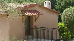 A small building with a tiled roof, a balcony with a metal railing, and potted plants on the railing. - Peaceful Garden Retreat, Berre (Berre-des-Alpes)