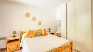 A bedroom with a wooden bed, bedside tables with lamps, a wardrobe, and wall decor. - Peaceful Garden Retreat, Berre (Berre-des-Alpes)