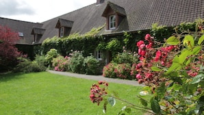 A row of houses with a well-maintained lawn and flowering bushes. - Chalet in France Near the Beach & Pool (Quend)