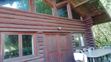 A log cabin with a dining area featuring a table and chairs.