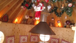 A cozy room with a wooden ceiling, a table with a lamp, and festive decorations. - Ventron Chalet With Hill Views (Ventron)