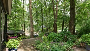 A garden with a pathway, potted plants, and a small structure. - Cozy Countryside Escape in Dalfsen (Dalfsen)