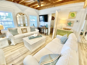 Relax in this inviting living room with a comfortable sofa, flat-screen TV, and natural views.