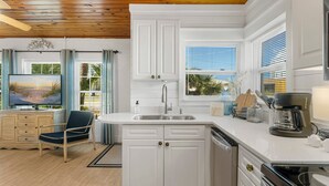 A modern kitchen with white cabinetry, a built-in sink, and a coffee maker. - 30ft from Perfect LAGUNA BEACH ~ Directly across the street from Beach Access #83 "Oleander West Cottage" (Panama City Beach)