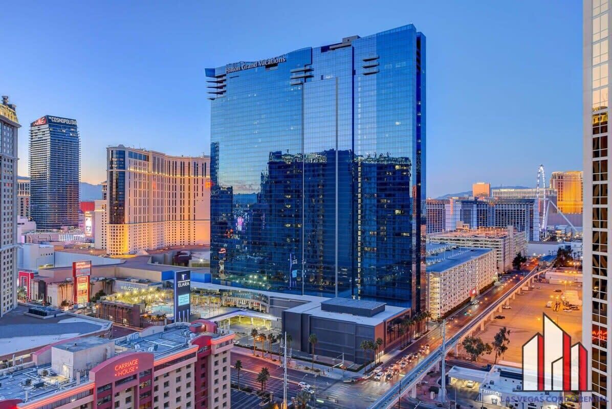 A high-rise hotel with a modern glass facade, located in a bustling urban area with other commercial buildings.