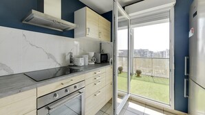 Cozinha moderna com forno embutido, micro-ondas e máquina de café.