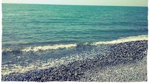 A beach with clear water and a pebbly shore. - D&D Lux Apartment 96. Clean, bright and modern.  (Batumi)