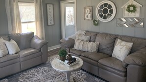 A living room with two sofas, a coffee table, and decorative wall art.