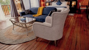 A bedroom with a bed, a sofa, a chair, and a small table.