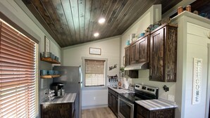 A kitchen with wooden cabinets, a stainless steel refrigerator, and a built-in oven.