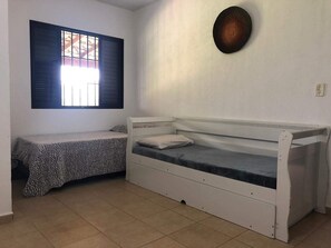 A room with a bunk bed, a small bench, a window with blinds, and a wall-mounted light fixture. - Sítio Refúgio do Alto (Piracicaba)