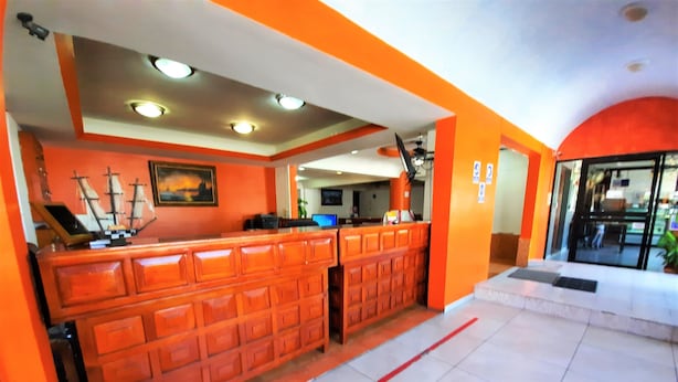 A reception area with a wooden counter, tiled flooring, and a ceiling with recessed lighting. - Hotel Costa Maria (Ciudad del Carmen)