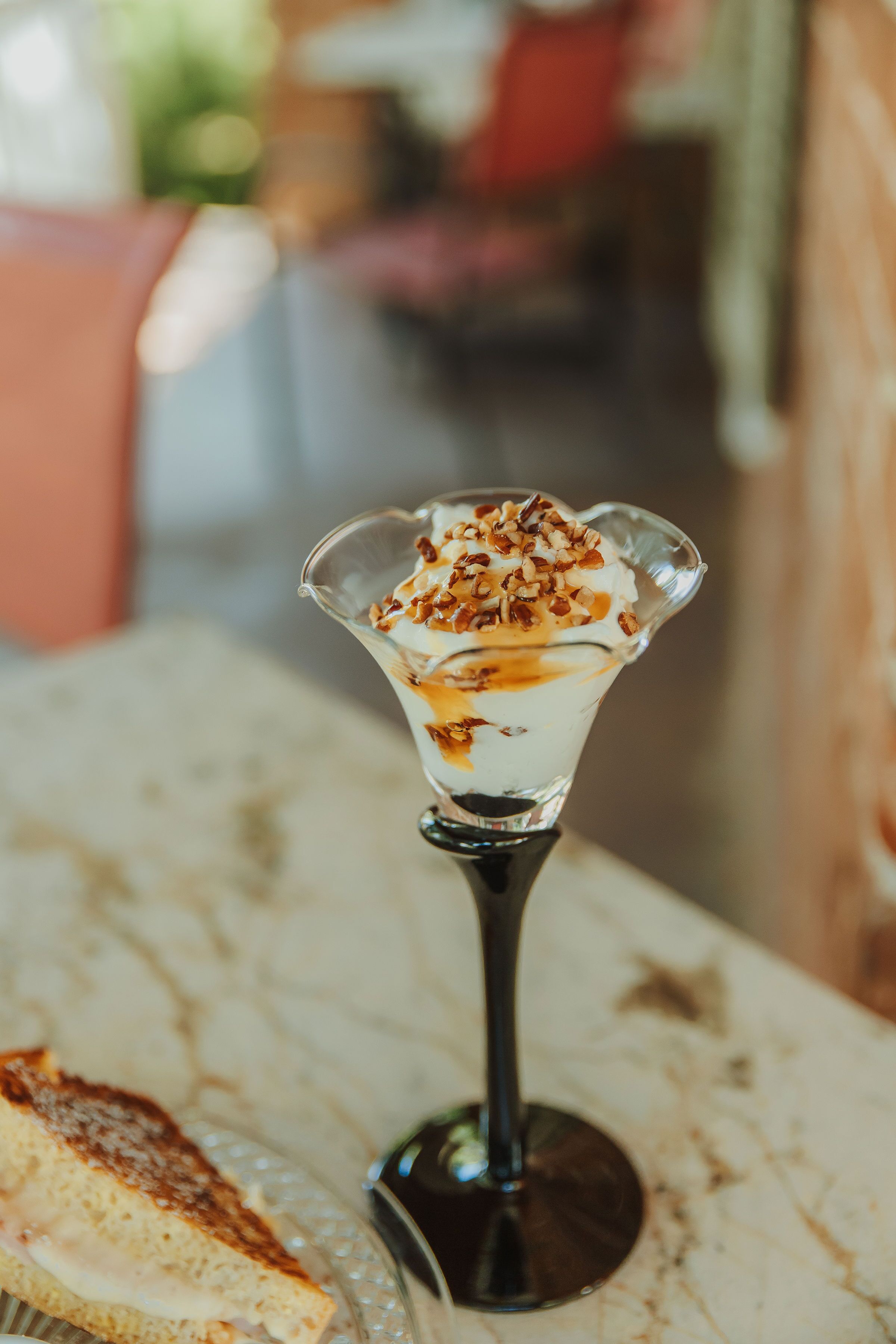 Un postre en un vaso sobre una mesa de mármol.