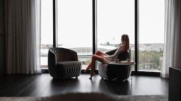 A room with a large window, a sofa, and a chair.