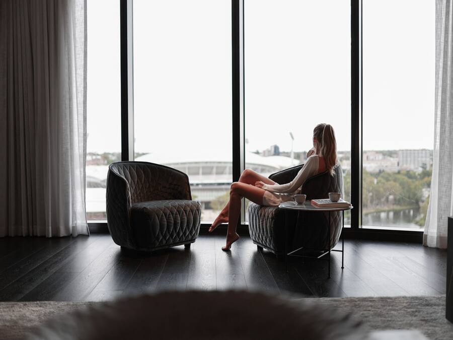 A room with a large window, a sofa, and a chair.