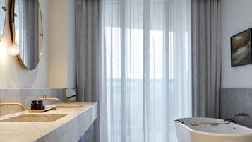 Un baño moderno con una bañera grande, un lavamanos doble y un espejo amplio.
