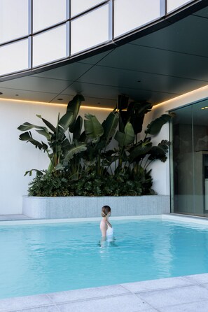 Una piscina al aire libre, sombrillas, sillones reclinables de piscina