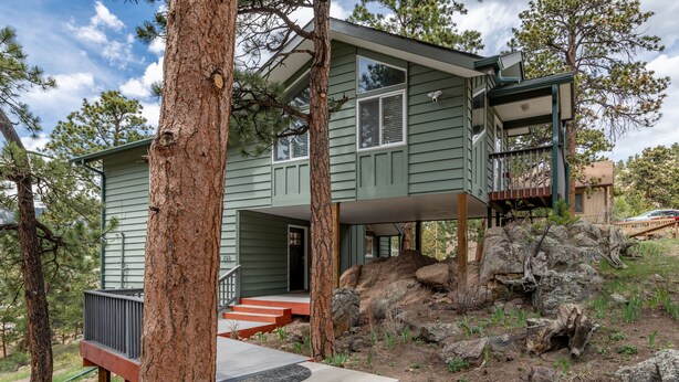 A two-story cabin with a deck and a staircase leading to the entrance. - Rocky Retreat: Relax in hot tub, 2.7 mi to RMNP, walking distance to town, #3370 (Estes Park)