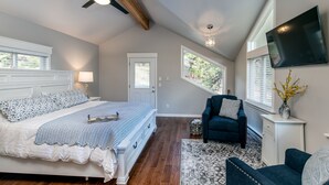 A bedroom with a bed, a chair, a TV, and a window. - Rocky Retreat: Relax in hot tub, 2.7 mi to RMNP, walking distance to town, #3370 (Estes Park)