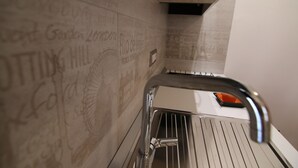 A narrow, tiled corridor with a metal handrail and a small window at the end. - DOMUS LEVI APARTMENT (Matera)