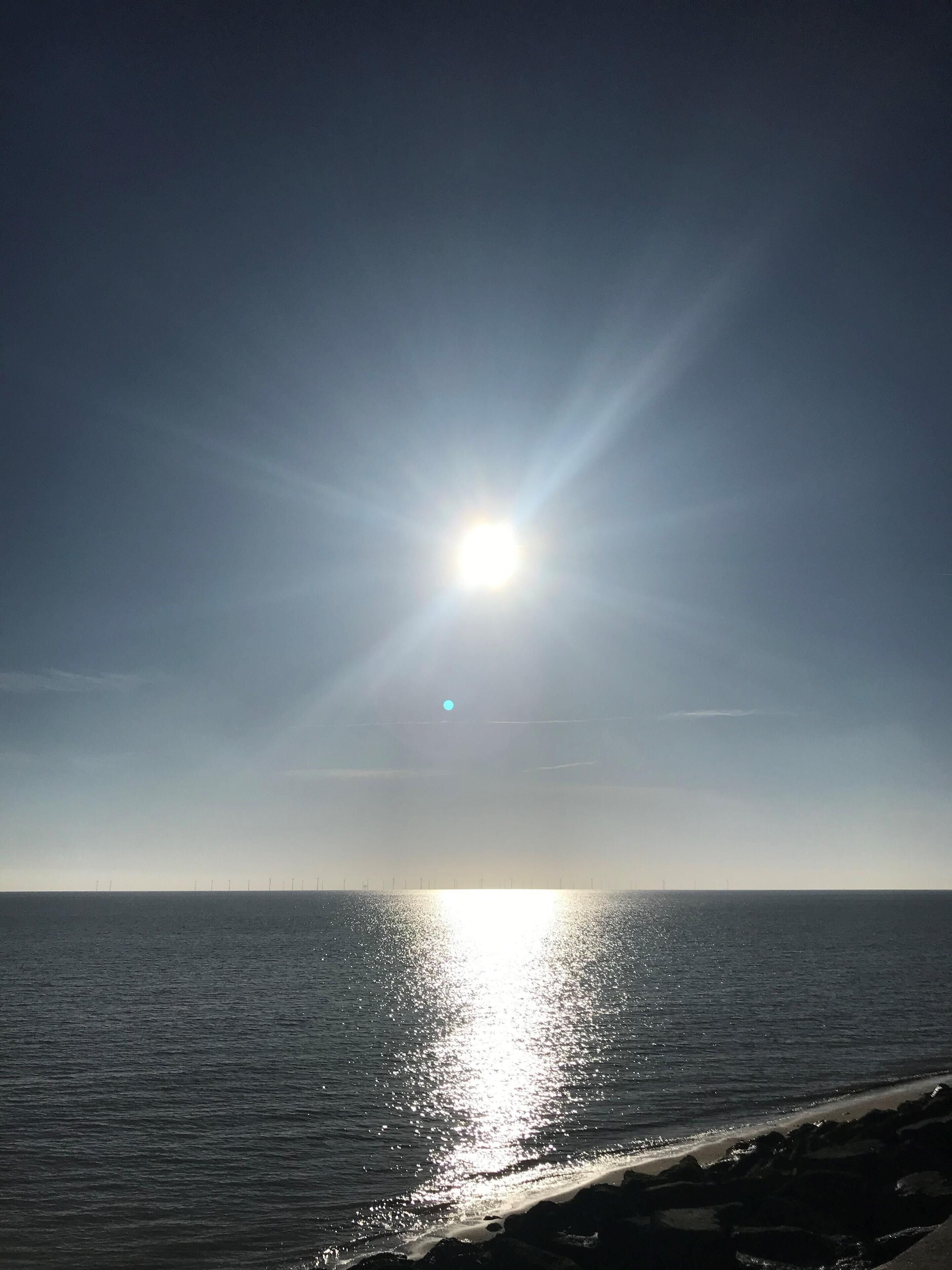 Un atardecer sobre un mar tranquilo con cielo despejado.