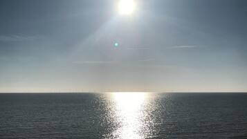Un atardecer sobre un mar tranquilo con cielo despejado.