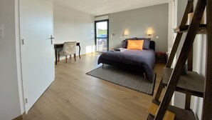 Une chambre moderne avec un lit, un bureau et une chaise. Il y a une grande fenêtre et une porte.